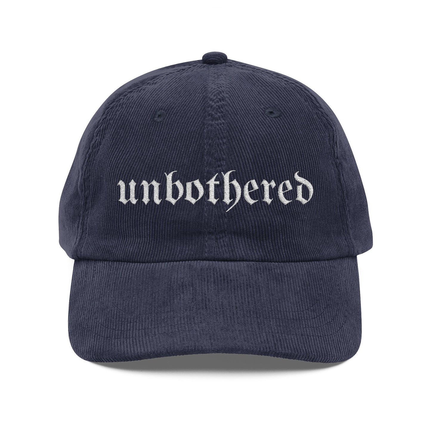 Navy blue cap with 'unbothered' text on a white background