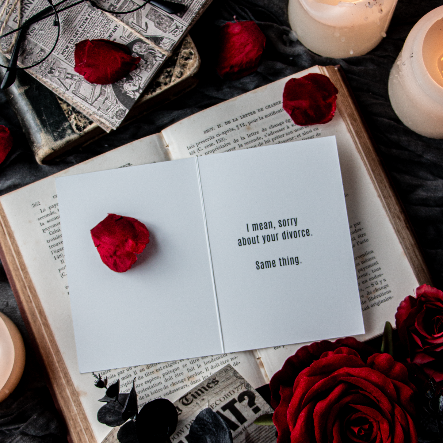 Open book with red roses and candles on a dark surface.