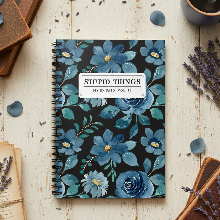 Notebook with blue floral design on a wooden surface with books and lavender.