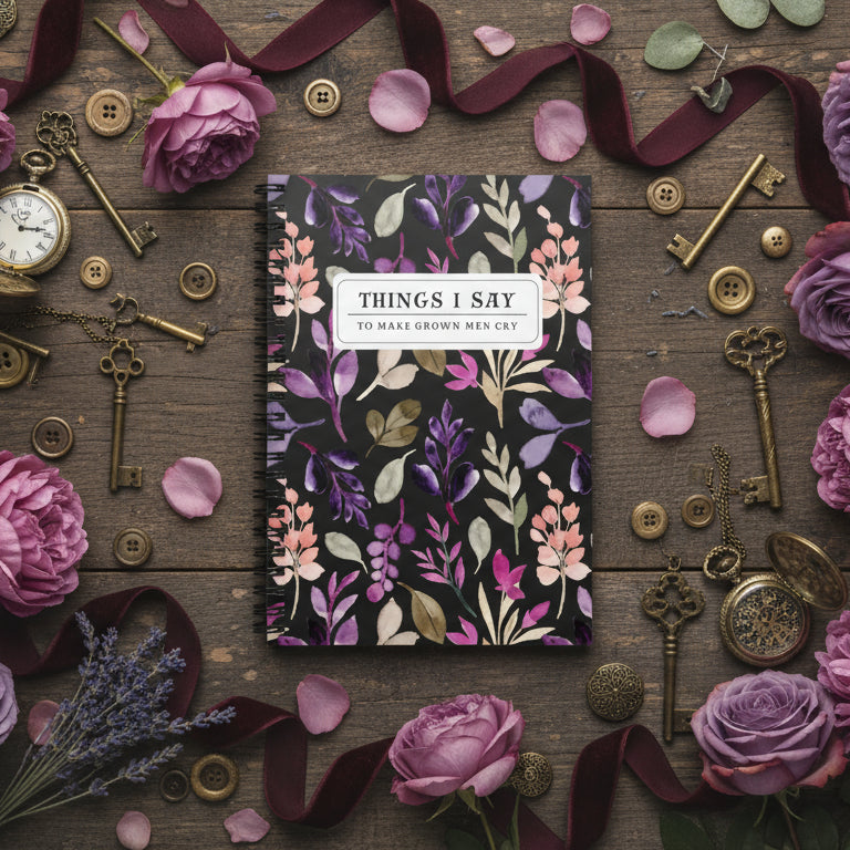 Floral notebook surrounded by keys, ribbons, and flowers on a wooden surface