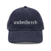Navy blue cap with 'unbothered' text on a white background