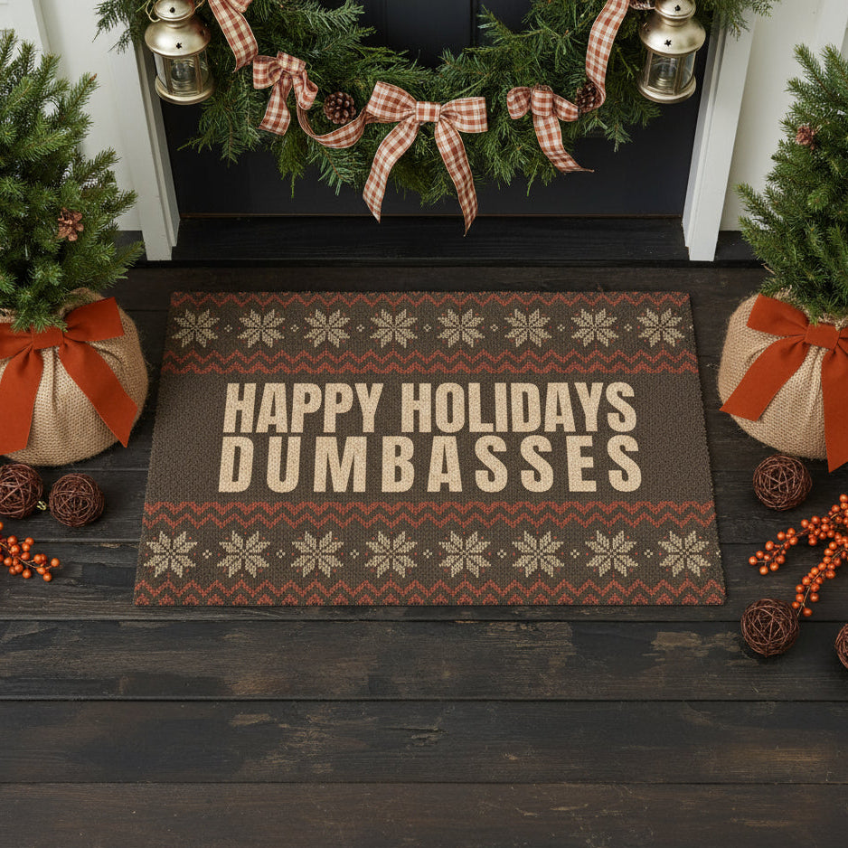 Decorative doormat with 'Happy Holidays Dumbasses' text in a festive setting.