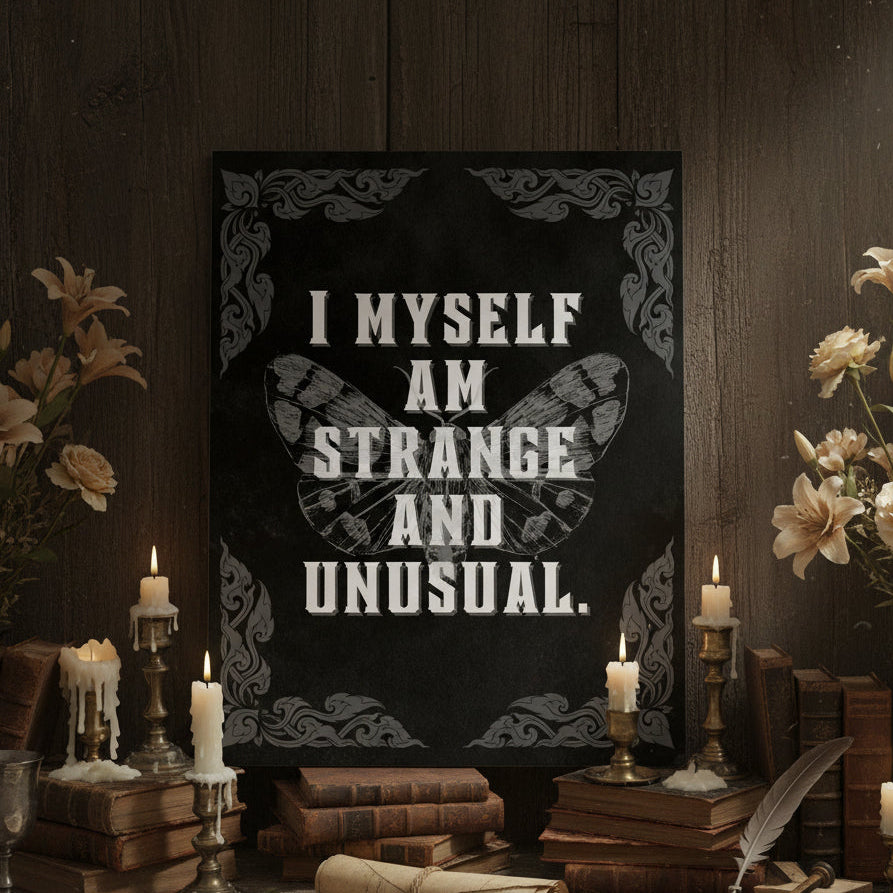 Decorative setup with a sign reading 'I myself am strange and unusual', surrounded by books, candles, and flowers.