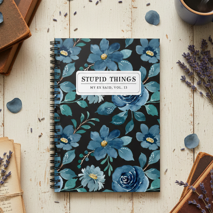 Notebook with blue floral design on a wooden surface with books and lavender.