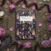 Floral notebook surrounded by keys, ribbons, and flowers on a wooden surface
