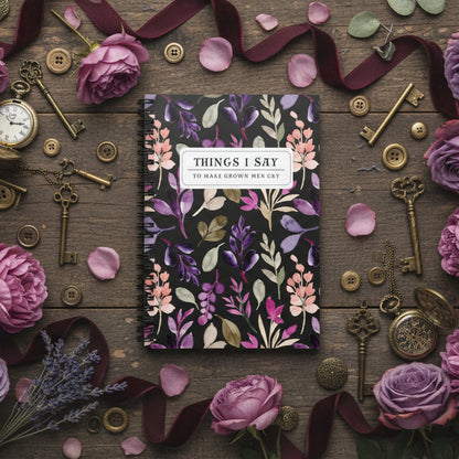 Floral notebook surrounded by keys, ribbons, and flowers on a wooden surface