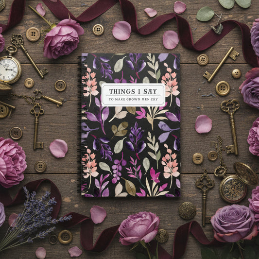 Floral notebook surrounded by keys, ribbons, and flowers on a wooden surface
