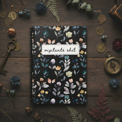 Notebook with floral design on a wooden surface with decorative items