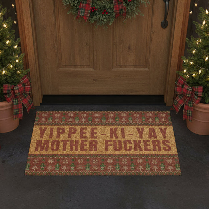Doormat with offensive text in front of a wooden door decorated for Christmas.